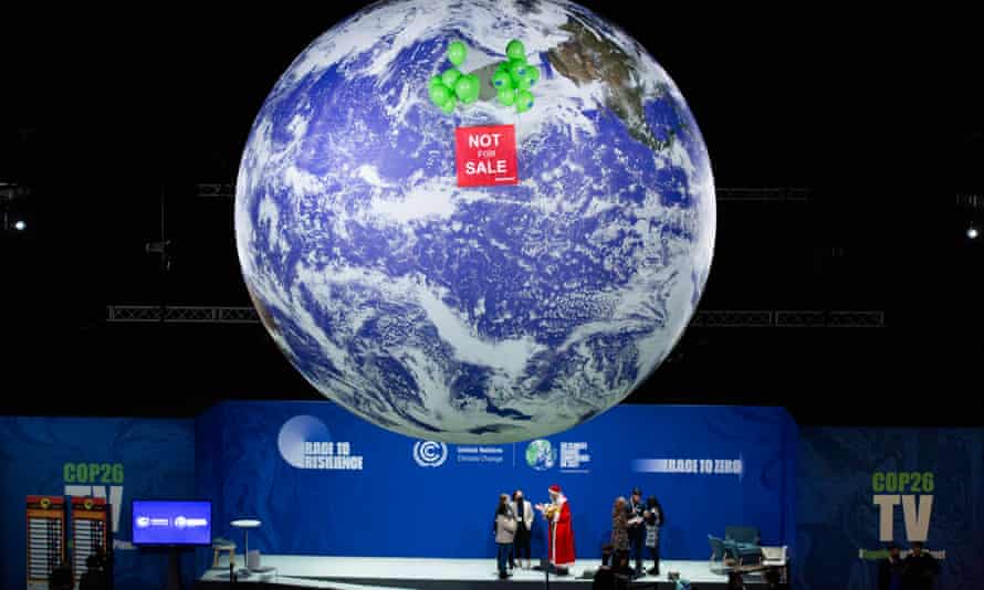 A huge cutout of the globe with a sign on it saying 'Not for sale' hanging in a darkened conference hall