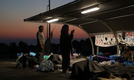 People pray at sunrise near a new temporary camp on the Greek island of Lesbos.