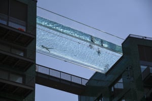 People swim in the Sky Pool, a transparent swimming pool bridge across two residential blocks in Nine Elms, London