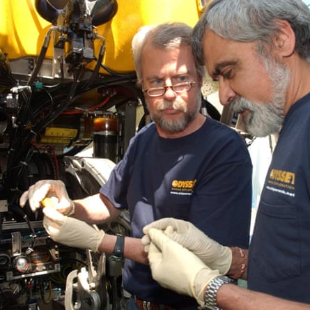 Ex-advertising man Greg Stemm, co-founder of Odyssey Marine Exploration, and project manager Tom Dettweiler (right) examine a coin from the Black Swan shipwreck in 2007