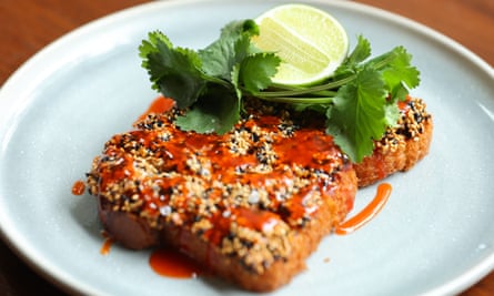 Sesame shrimp toast with coriander sprigs and a slice of lemon on a pale blue pie plate
