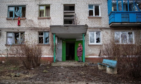 A woman stands outside her building, damaged by a Russian military strike, in Kramatorsk.