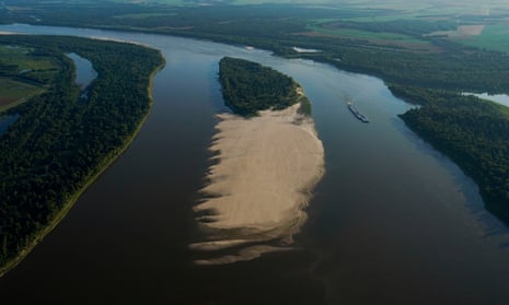A tugboat with barges navigates around a sandbar during a period of low water level in the Mississippi River  in West Feliciana Parish, Louisiana.