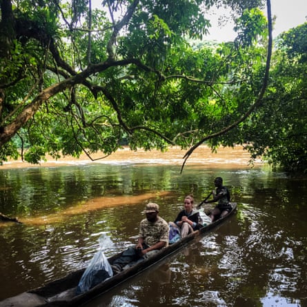 Horeb (L) and Lisa cross the Epulu River on the way to the Bapela outpost inside of the Okapi wildlife reserve, Democratic Republic of Congo