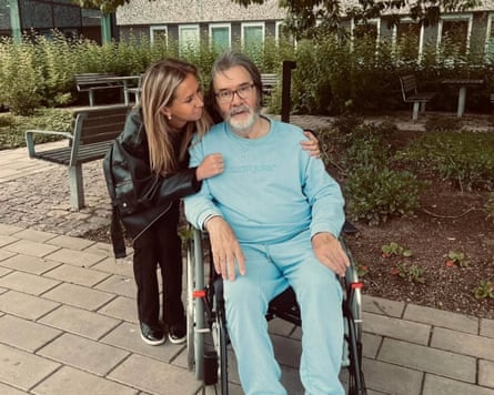 Horace George Mason in a wheelchair and his daughter Michelle, who has her arms around him.