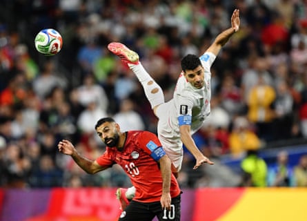 Mehdi Taremi leaps above Mohamed Salah for the ball