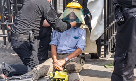 Police attempt to free a climate activist who locked himself to a railing outside parliament in September. Part of the bill refers to offences such as locking-on, tunnelling and blocking roads.