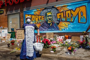 A protester stands near a memorial following a day of demonstrations in a call for justice for George Floyd