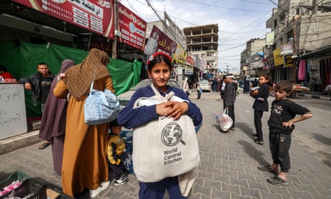 A girl carries a canvas bag filled with food aid bearing the logo of non-profit World Central Kitchen in Rafah, southern Gaza, last month