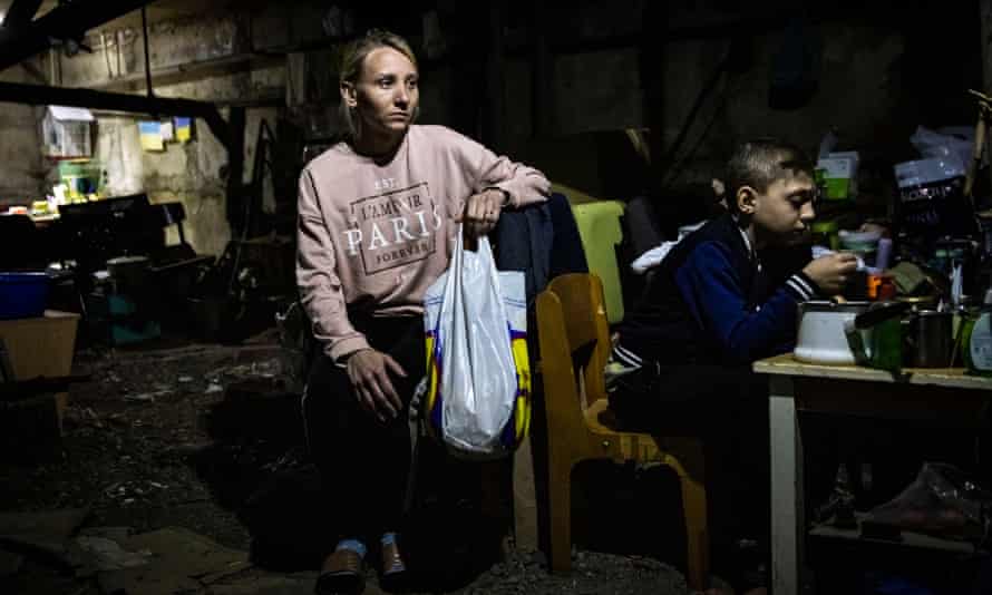 Timofiy Seidov eats next to his Aunt Yana Sotnikova in the basement in Kutuzivka.