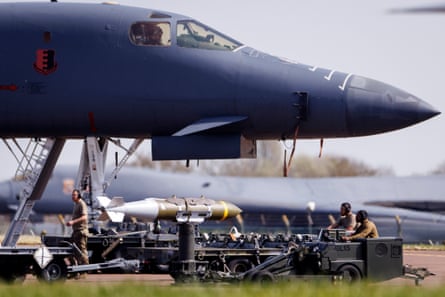 US air force military personnel tend to Jdam precision-guided munition and a Rockwell B-1 Lancer heavy bomber.