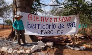 Adriana next to the camp’s welcome banner, which reads: ‘Welcome to a territory of peace.’