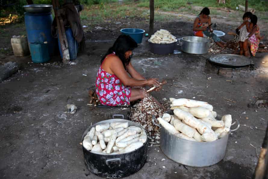 A mother prepares food for her children in the village of Kamayura, in Xingu national park. Brazil.