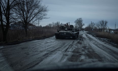 Ukrainian serviceman rides in an armoured vehicle along a road near a front line in the Kharkiv region