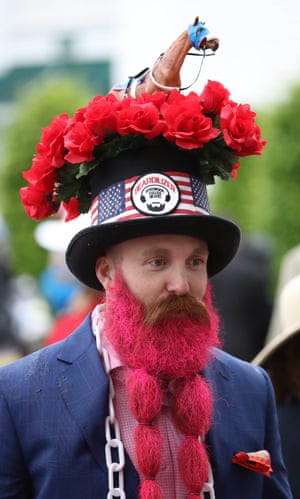 A man acessorizes his hat and beard