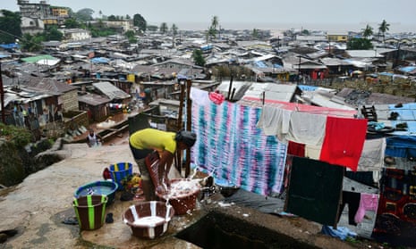 A woman washes clothes in Kroo town slum in Freetown.