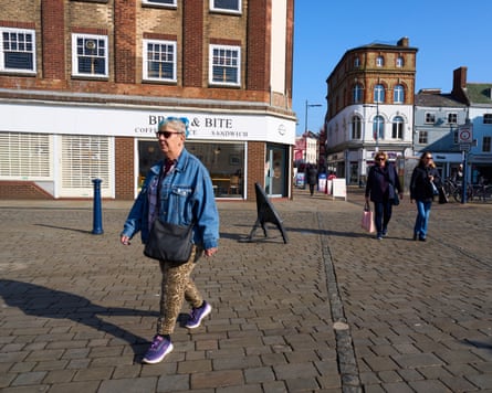 People walk through a town on a sunny day