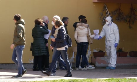 People line up to undergo a voluntary test for coronavirus in Vò, Italy, 8 March 2020. 
