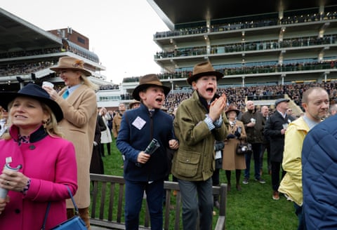 Young racegoers cheer during racing at Cheltenham Racecourse.