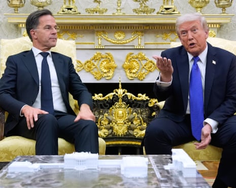 Rutte looking at Trump as he talks to cameras and photographers