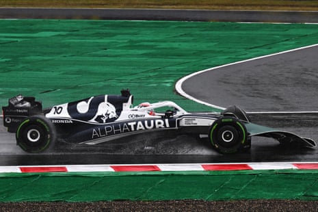 Gasly drives with an advertising board on his front wing.