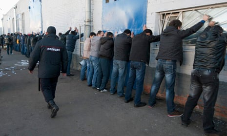 Russian police detain migrant workers during a raid at a vegetable warehouse complex in Moscow.