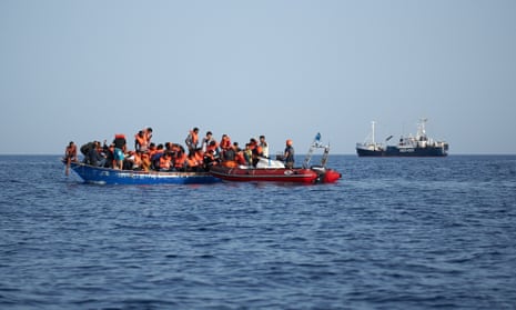 The rescue ship Alan Kurdi picking up 44 people from a wooden boat in the Mediterranean