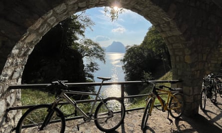 Bikes under stone arch with lake view