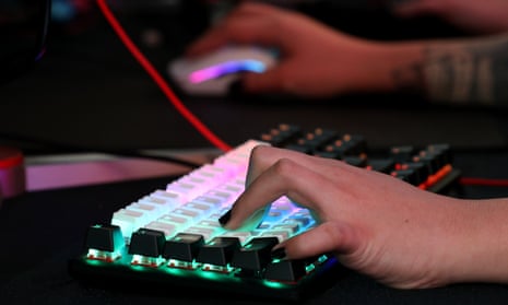 A computer user's hands at work on a back-lit keyboard and mouse