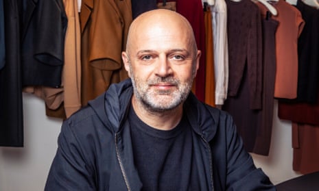 Hussein Chalayan in front of a rail of his designs