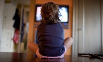 Young girl watching television with her back to us