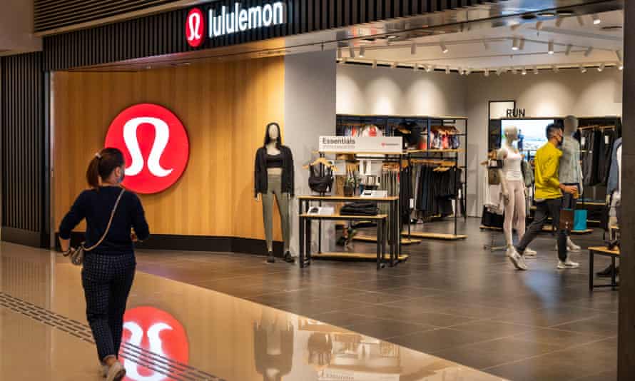 A shopper walks past the Canadian sportswear clothing band, Lululemon logo and store seen in Hong Kong.