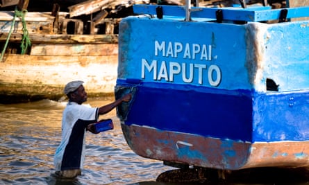 A man gives his boat a fresh coat of paint in the village of Catembe near Maputo, Mozambique
