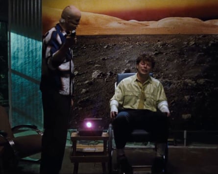 Man standing with man in chair