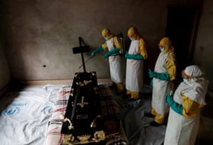 A paramedic sprays a room during the funeral of a person suspected of dying of Ebola in Beni, Democratic Republic of Congo.