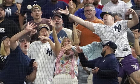 Fans reach for a foul ball by New York Yankees' Aaron Judge against the Texas Rangers. The slugger had earlier hit his record 62nd home run