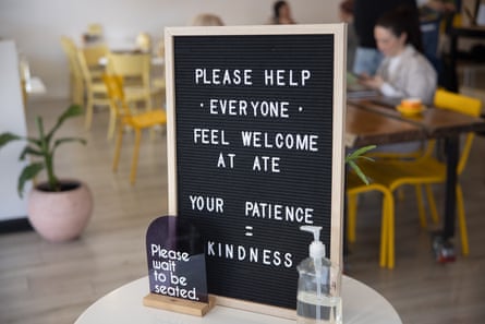 A sign next to a podium table that says “Please help everyone feel welcome at ATE. Your patience = kindness.”