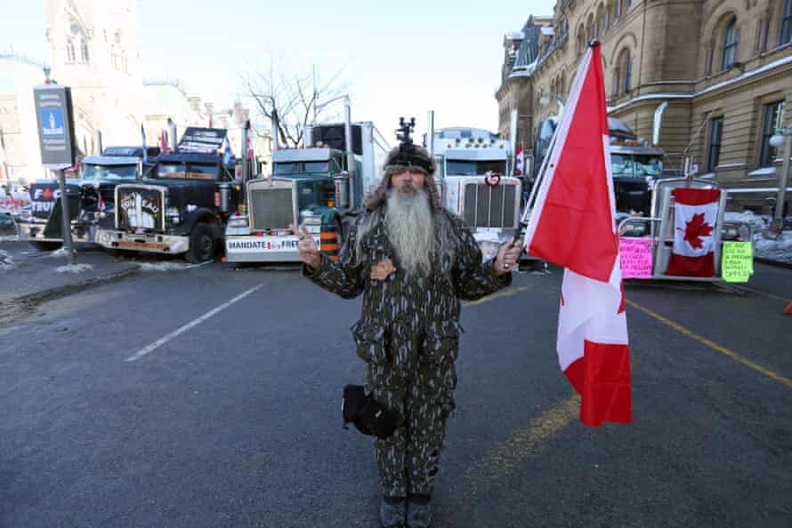 A man holds a Canadian flag near Parliament Hill as demonstrators continue to protest the vaccine mandates implemented by Prime Minister Justin Trudeau on Monday.