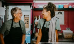 Female owner and coworker laughing in food truck kitchen<br>Adobe Article 2 - Hero