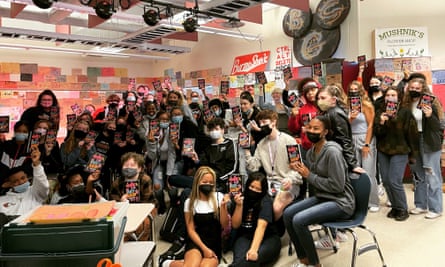 Students hold up copies of This Book is Anti-Racist by Tiffany Jewell.