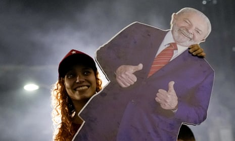 A Lula supporter in Rio carries a lifesize cutout of the former president as the votes are counted in Brazil.