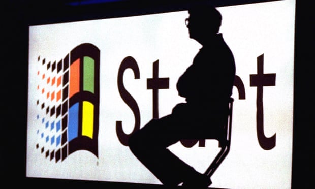 Bill Gates sitting on a stage, silhouetted against a Windows 95 logo