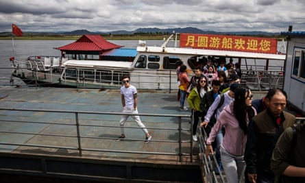Chinese tourists disembark from a boat on the Yalu river.