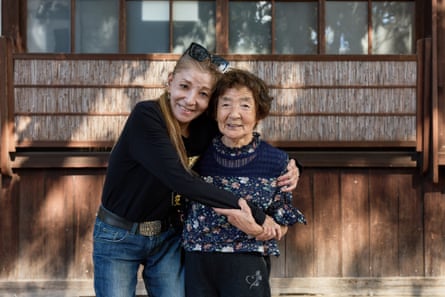 Nishimura hugs her mother outside a wooden building.