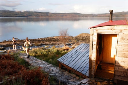 Two women running from lochside sauna towards the loch for a swim