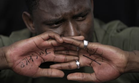 A man displays his hands, on which he has written ‘justice’ and ‘1.5’