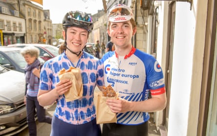 Wearing cycling gear, they eat pastries from a paper bag