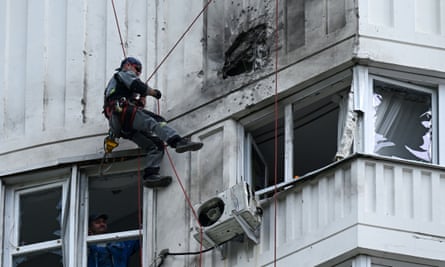A specialist inspects the damaged facade of a multi-storey apartment building after a reported drone attack in Moscow.