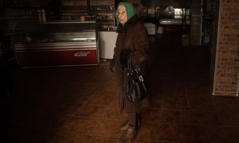 A woman waits to be served at one of the only grocery stores open in Bakhmut.
