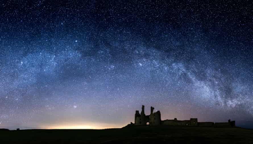 The Milky Way arcs over Dunstanburgh Castle, Northumberland.
